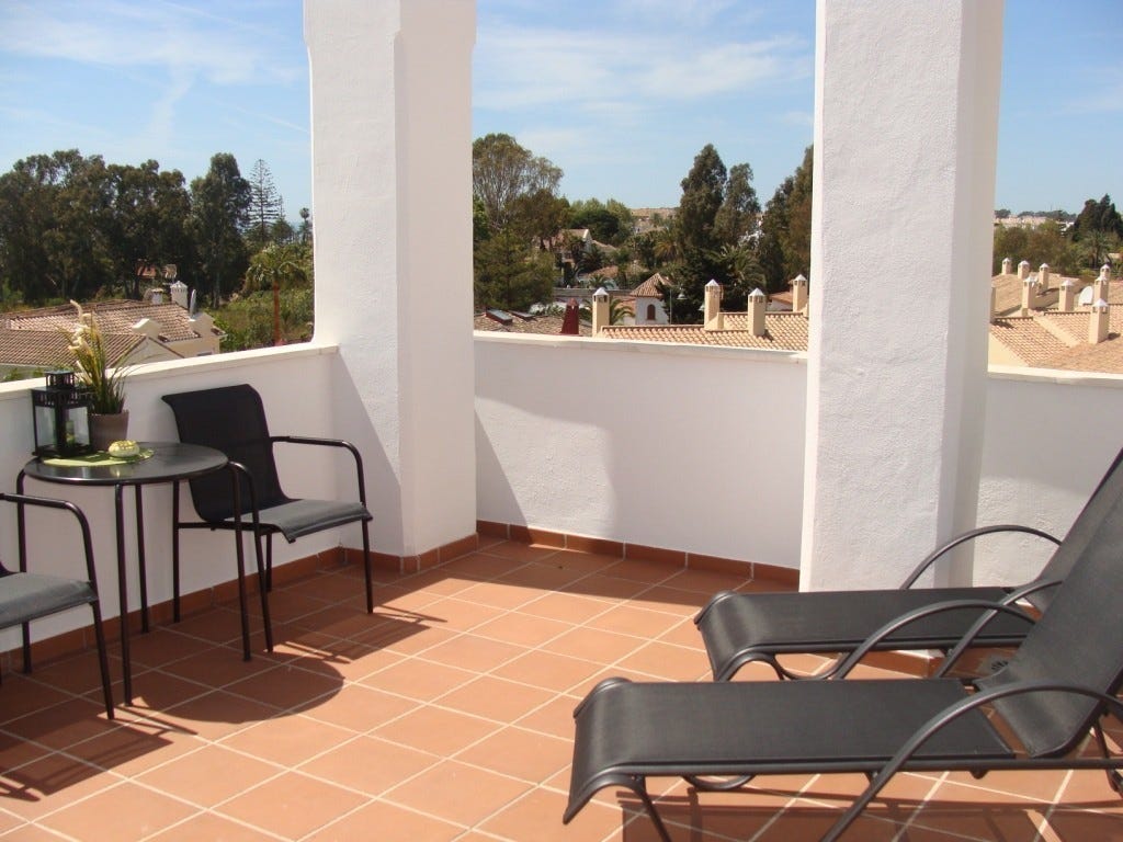 Takterrasse utenfor master soverom med stoler, bord, solsenger og markise. Galleribilde