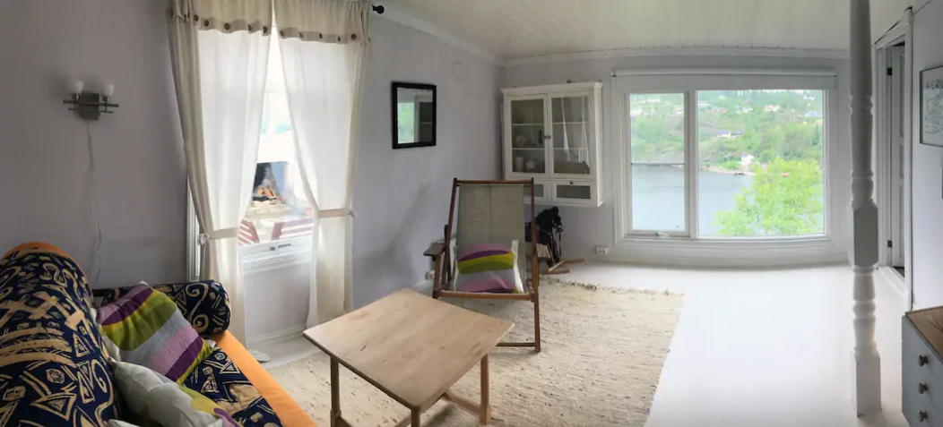 Stue i underetasjen med sovesofa, prosjektor i taket og store vinduer Galleribilde