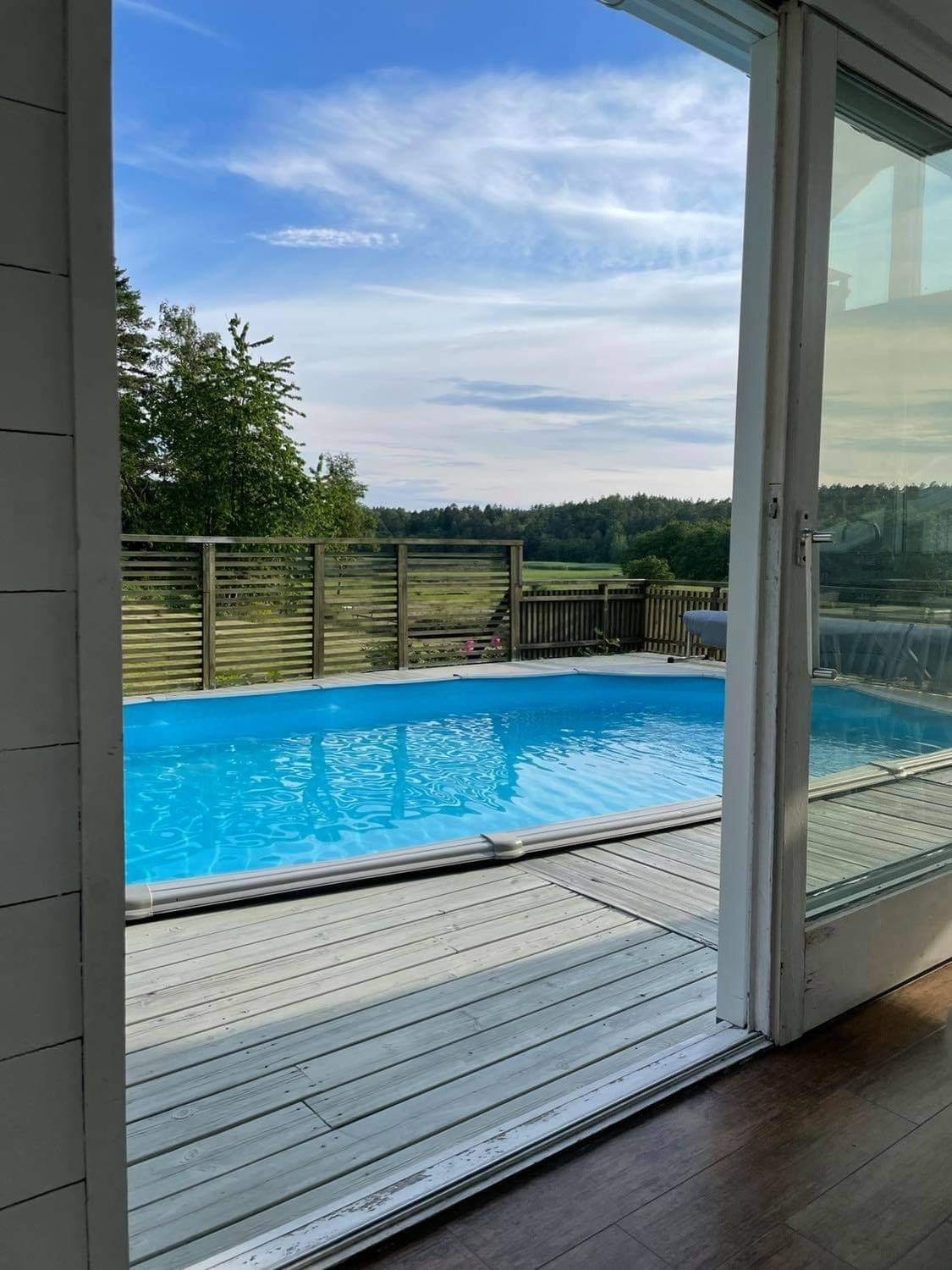 Ute på plattingen med bassenget og sittegruppe med grillen fra bryggerhuset Galleribilde