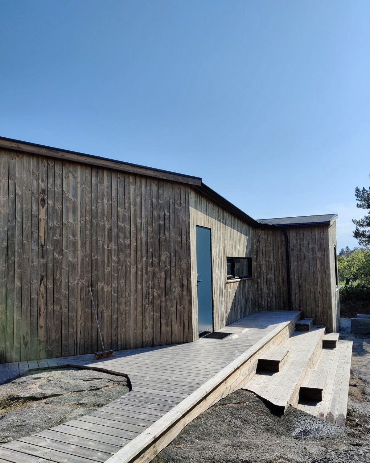 Ettermiddagssol i sittetribune ved inngangsdøra til hovedhytta Galleribilde