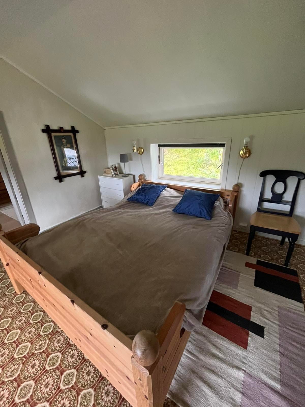 Ett rom med en dobbeltseng og plass til barneseng. Galleribilde