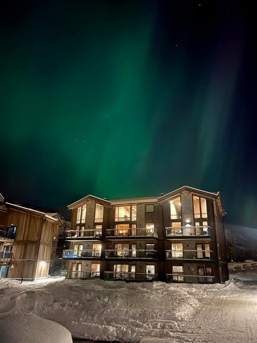 Bilde av leilighetsbygg med nordlys (bilde tatt 1 januar 2025). Galleribilde