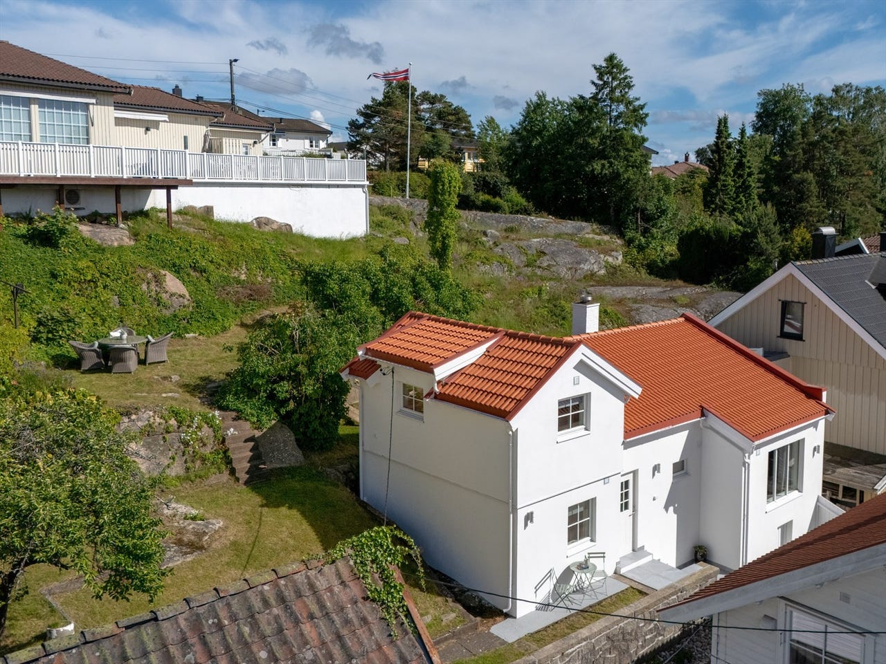 Fra smijernsporten til utsiktsplatået - hvitpusset hus på Kråkerøy. Pusset opp i 2025. Terrassert hage med flott utsikt.