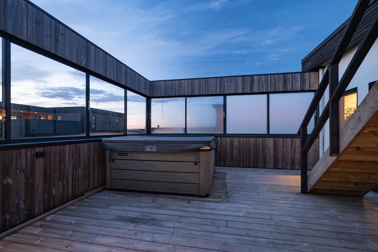 Åpen, men skjermet terrasse med jacuzzi og trapp opp til øverste takterrasse
