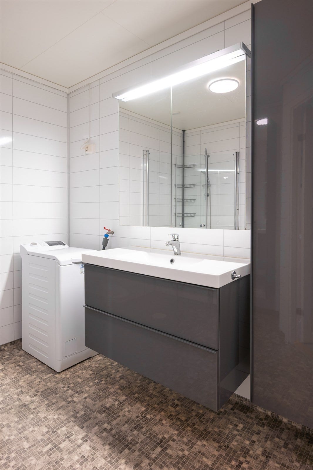 Stilren innredning, wc, dusjhjørne og opplegg for vaskemaskin