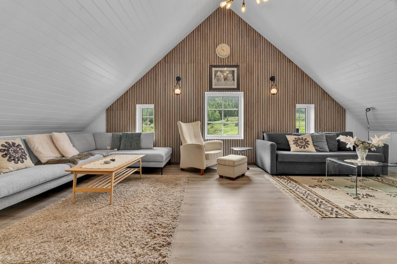 Boligen har loftstue med full takhøyde og moderne interiørdesign med spilevegg.