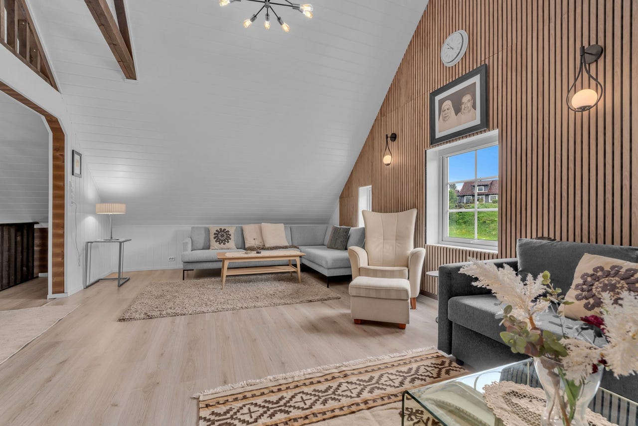 Loftstuen har spilevegg som er et funksjonelt designelement som tilfører varme og dybde i rommet.