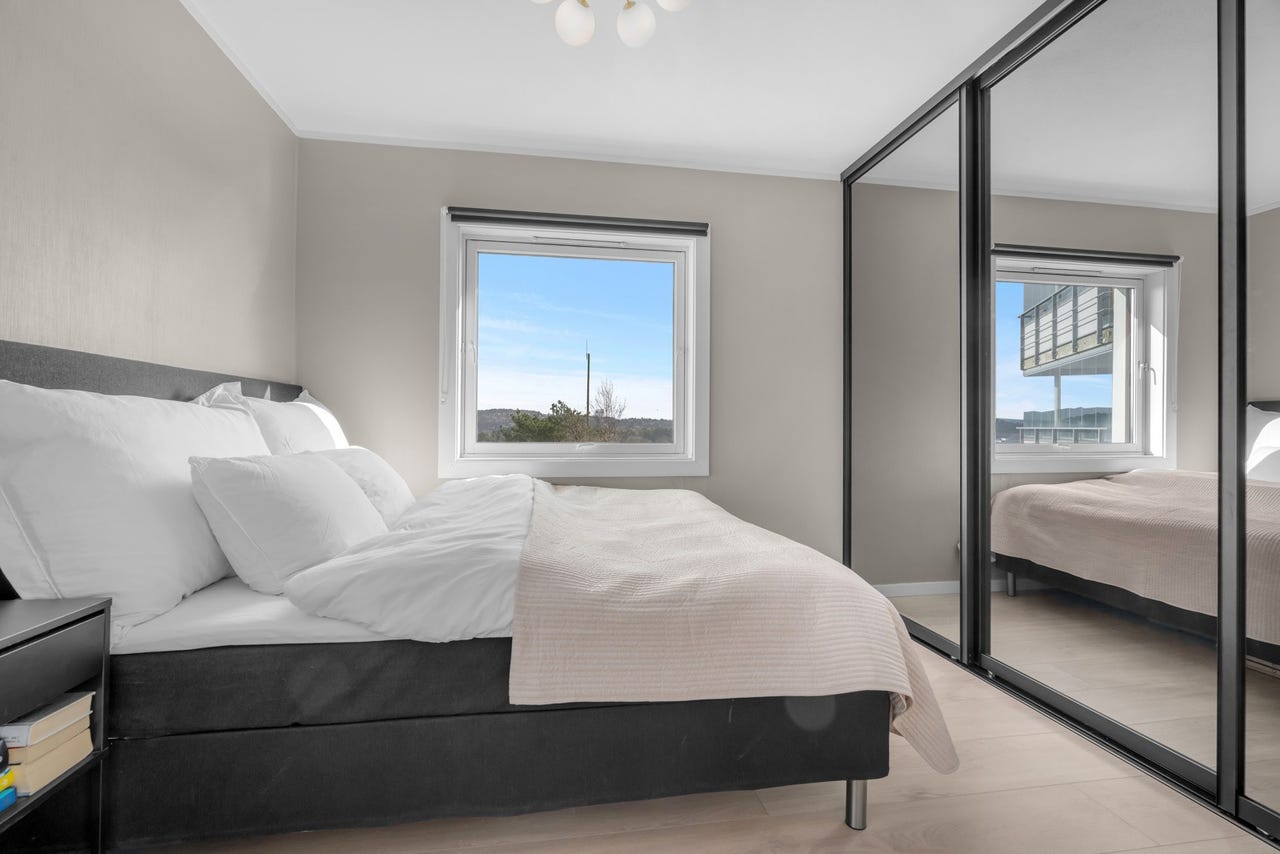 Hovedsoverom med stor skyvedørsgarederobe.