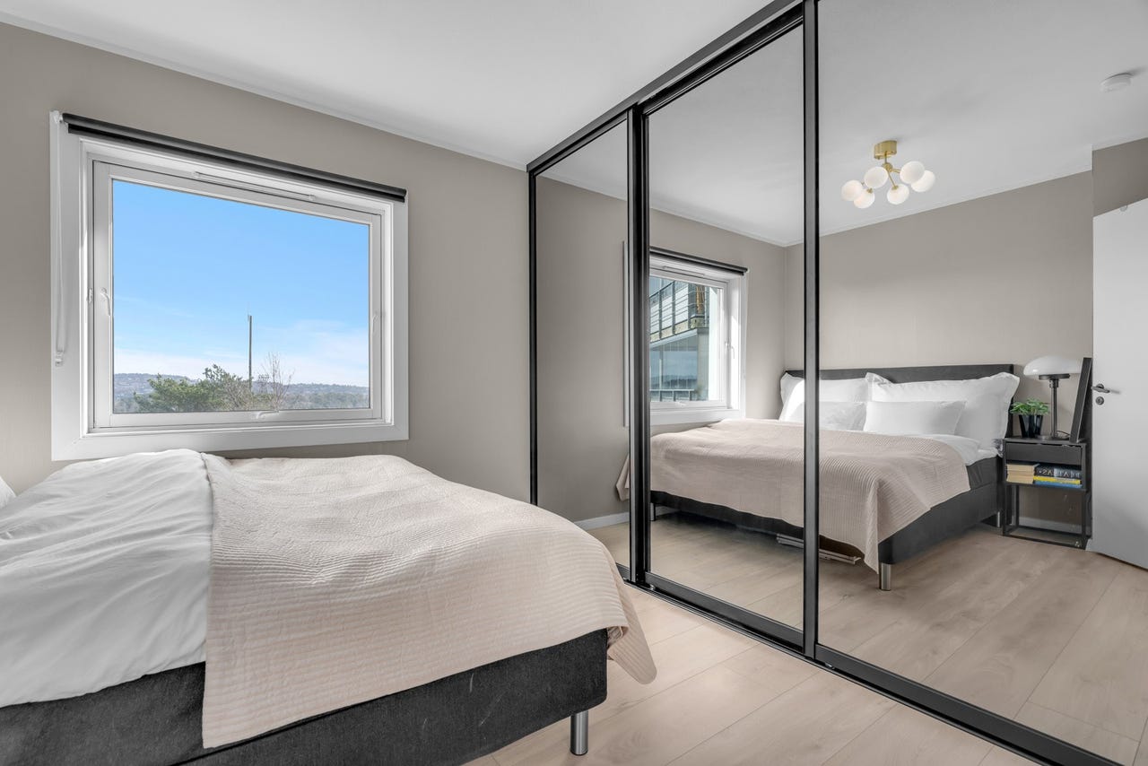Hovedsoverom med stor skyvedørsgarederobe.