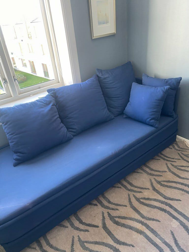 Blå sovesofa med løse puter
