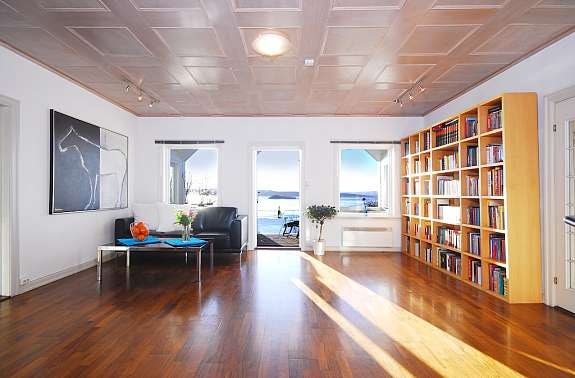 Den midterste stuen har panoramautsikt utover fjorden og utgang til balkong og deilig, stor hage. Galleribilde