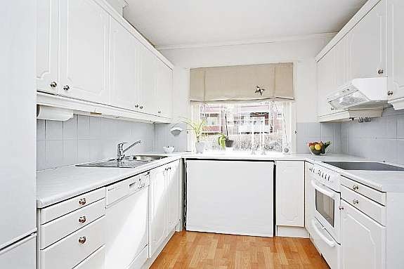 Pent kjøkken med hvit profilert innredning - Bra med benk- og skapplass Galleribilde