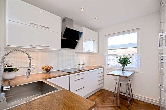 Designkjøkken med høy standard med integrerte hvitevarer og marmorfliser på vegg. Galleribilde