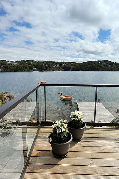 Ny terrasse med trebord og glassrekverk Galleribilde