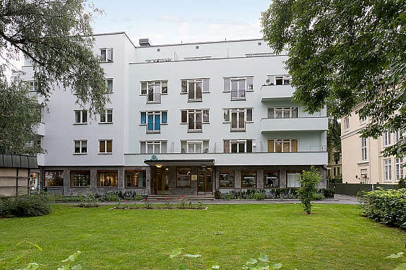 Bygårdens hage/inngangsparti er pent opparbeidet med gressplen, blomster og trær. Galleribilde