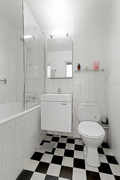 Delvis flislagt bad med innmurt badekar, servant og speilskap med belysning. Galleribilde