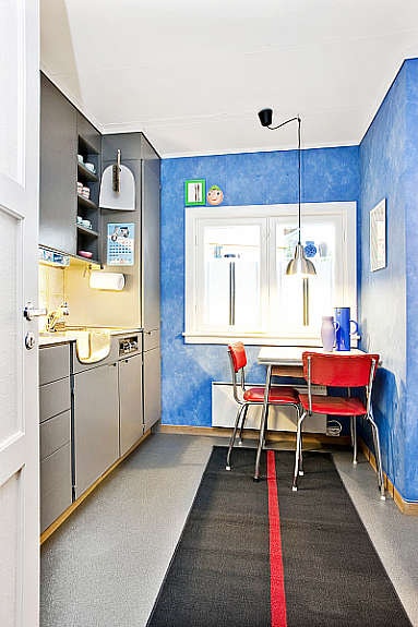 Kjøkkenet er godt utnyttet, med malt innredning. Det ligger fliser over benken. Galleribilde