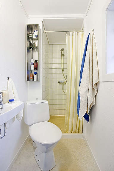 Badet er lite, men funksjonelt med dusjnisje, vask og wc. Det ligger belegg på gulv, baderomsplater og malt tapet på vegg. Galleribilde