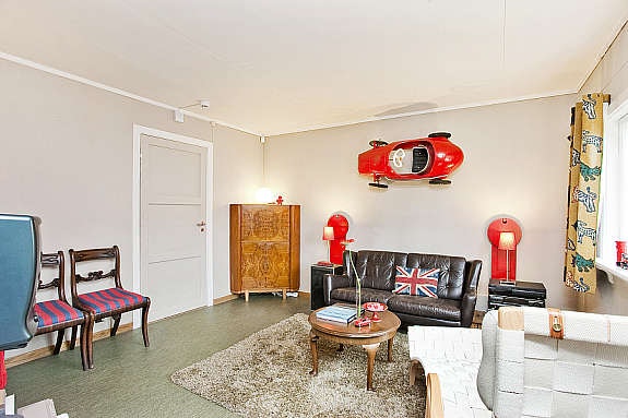 Det ligger linoleum på gulv, malt tapet på vegg, takess i himling. Døren fører ut til gangen. Galleribilde