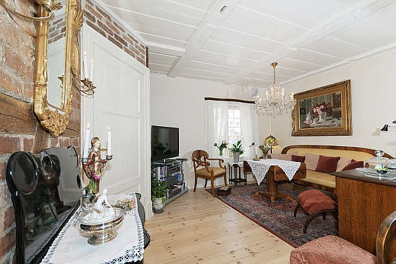 Stue i 1. etasje med tregulv med varmekabler, dels gips og dels teglstensvegger. Galleribilde