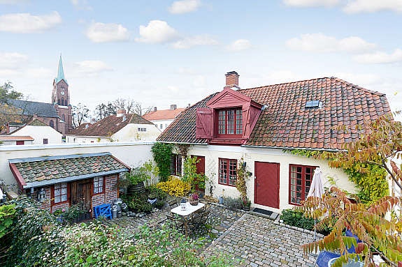 Eget gårdsrom, steinlagt med mye grønne planter. Galleribilde