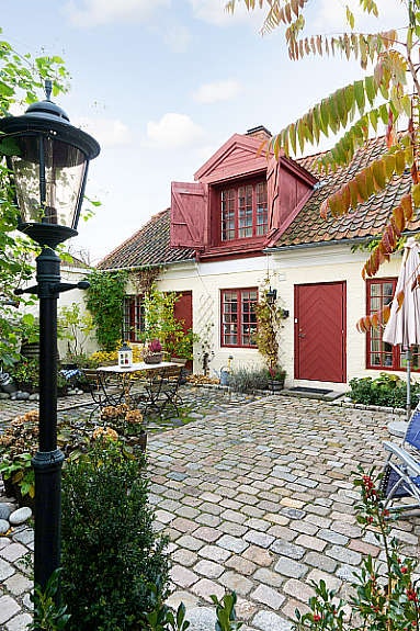 Eget gårdsrom, steinlagt med mye grønne planter. Galleribilde