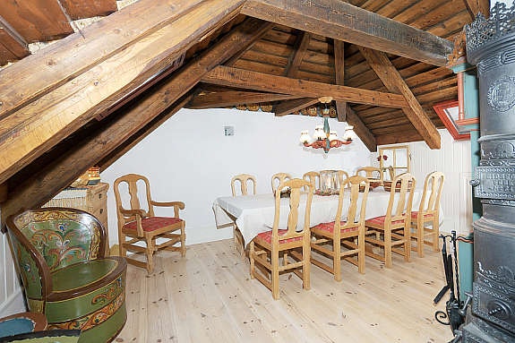 Spisestue på loft, med vedovn til høyre i bildet. Galleribilde
