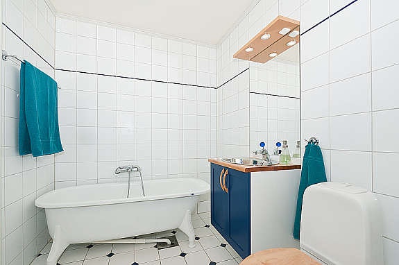 Det kombinerte badet/vaskerommet har w.c., badekar, innredning med servant og opplegg for vaskemaskin. Galleribilde