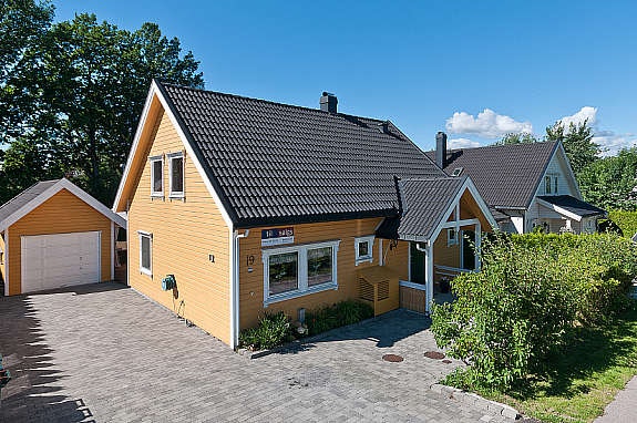 Stor gårdsplass med belegningstein frem til garasje og inngangsparti. Galleribilde