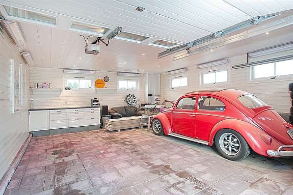 Isolert dobbel garasje med arbeidsbenk og heller på gulv. Galleribilde