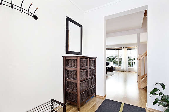 Lys entrè med parkettgulv, malt tapet på vegg, malte plater i himling. Galleribilde