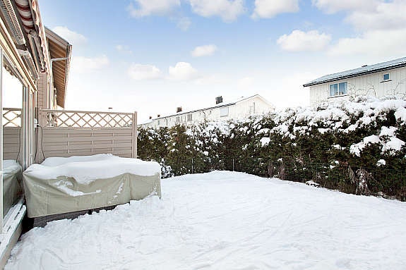 Hekk og levegg gjør uteplassen usjenert. Det er montert elektrisk terrassemarkise. Galleribilde