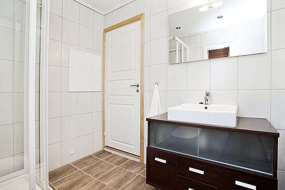 Bad i 2.etg med god arealutnyttelse. Det ligger fliser med varmekabler på gulv, fliser på vegg, malte plater med downlights i himling. Finèr innredning med vask, dusjkabinett, wc, opplegg til vaskemaskin. Galleribilde