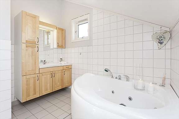 Delikat baderom på loftsplanet med boblebadekar og flott innredning. Galleribilde