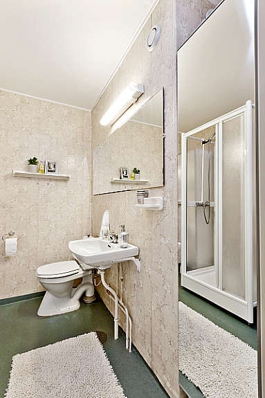 Eldre bad med wc, servant, dusjkabinett, ventil på vegg og opplegg for vaskemaskin. Galleribilde