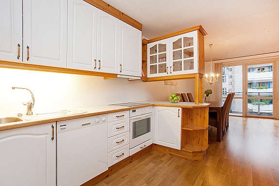 Kjøkkeninnredning med integrert komfyr og keramisk topp Galleribilde