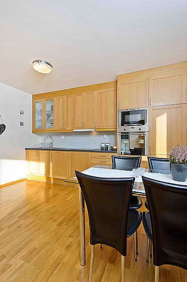 Velholdt kjøkkeninnredning med profilerte eikefronter og glasskap. Galleribilde