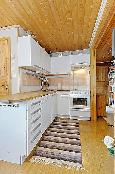 Kjøkken i kjellerleiligheten er innredet med hvite fronter, utstyrt med skap og god plass til hvitevarer. Galleribilde