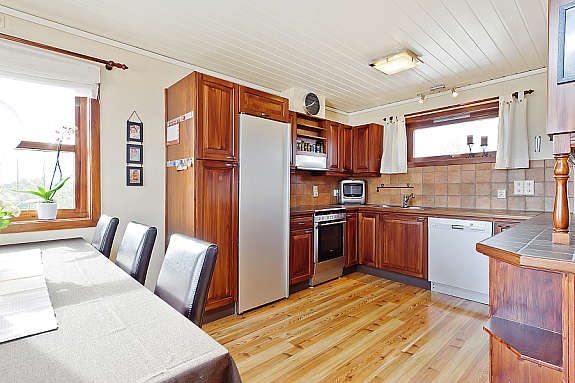 Meget pent kjøkken med beiset fronter, fliser over benkeplate, spiseplass, god skap- og benkeplass. Galleribilde