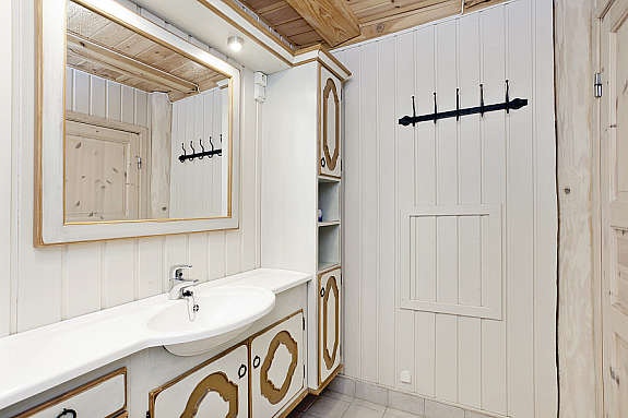 Romslig bad/wc i 1 etg. innredet med lasert innredning med servantplate, høyskap, speil og belysning, wc, dusjkabinett. Galleribilde