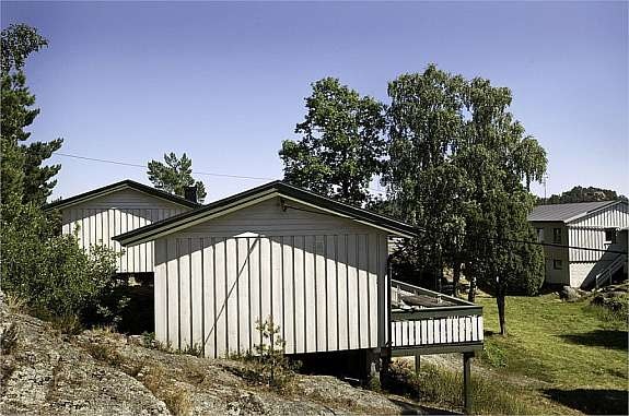 Begge de frittliggende hyttene til venstre i bildet og hovedhytta til høyre i bi Galleribilde