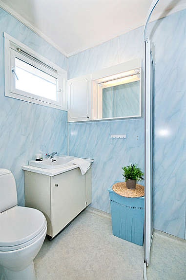 Badet er innredet med dusjhjørne, wc og skap med servant. Galleribilde