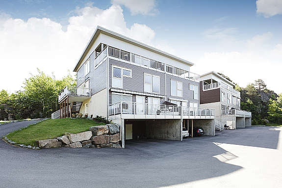 Nyere oppførte firemannsboliger med vestvendte balkonger og carport Galleribilde