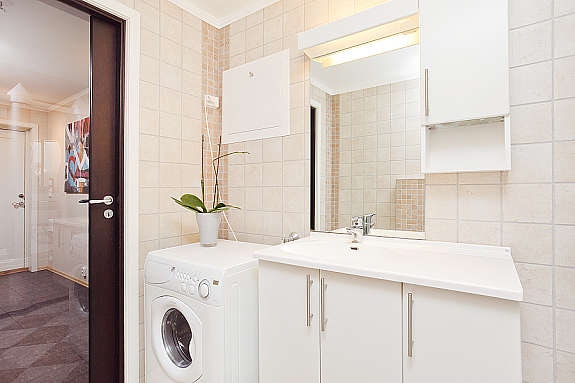 Badet har fliser på gulv og vegger, samt opplegg for vaskemaskin Galleribilde