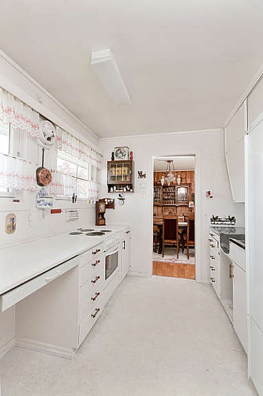 Kjøkken har hvit innredning fra byggeår. Galleribilde