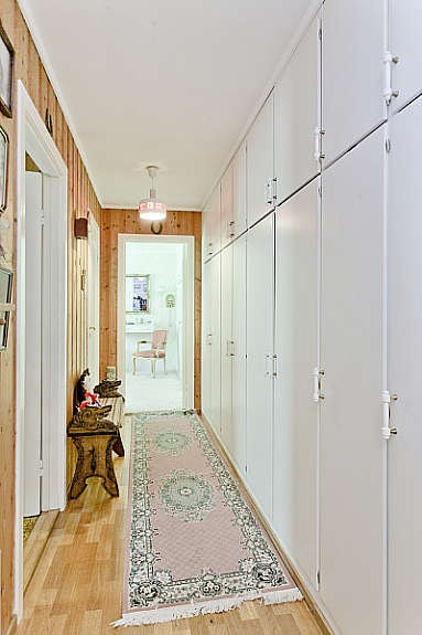 Soveromsgang med lang skaprekke og trappeluke til lagringsloft. Galleribilde