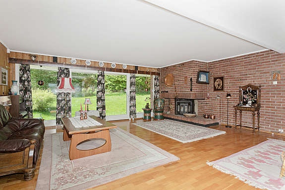 Romslig stue med eikeparkett,murt peis og store vindusflater. Galleribilde