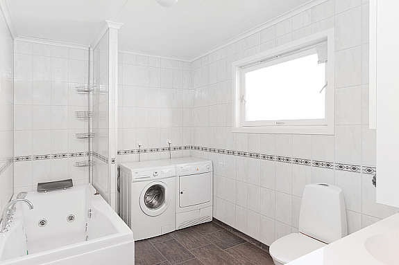 Bad i 1. etasje. Inneholder: vask med skap, wc, tilkoblinger til vaskemaskin og badekar. Galleribilde