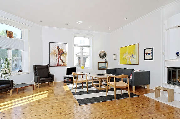 Lys, pen og romslig stue med downlights i tak og flott peisovn. Galleribilde