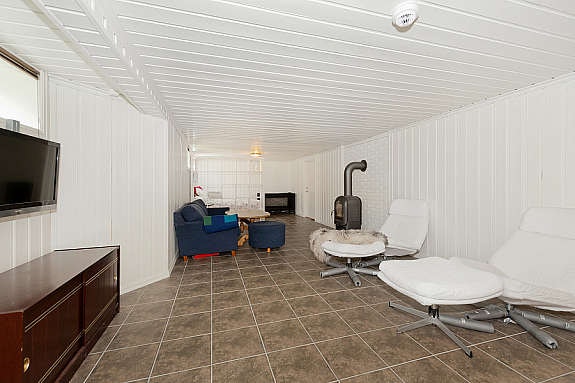 Romslig kjellerstue med vedovn Galleribilde